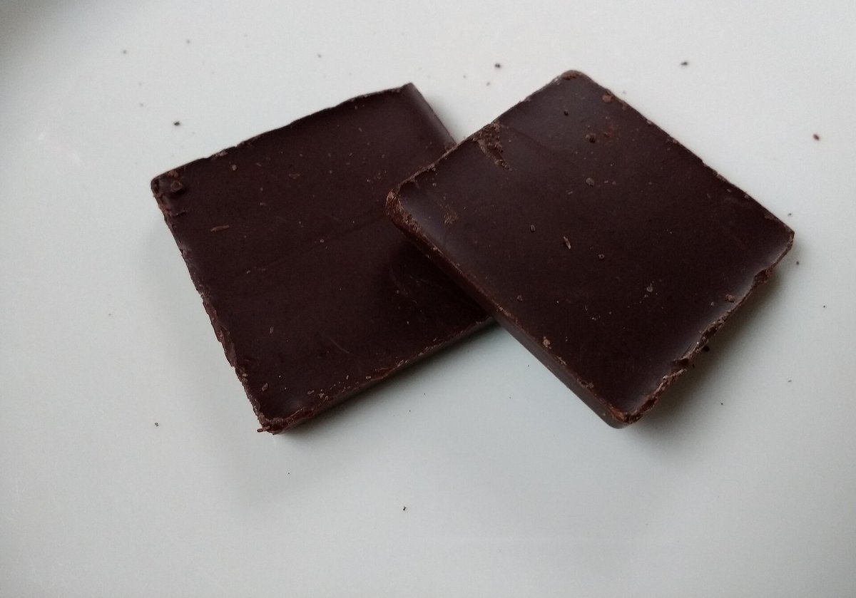 Morceaux de chocolat noir sur une surface claire