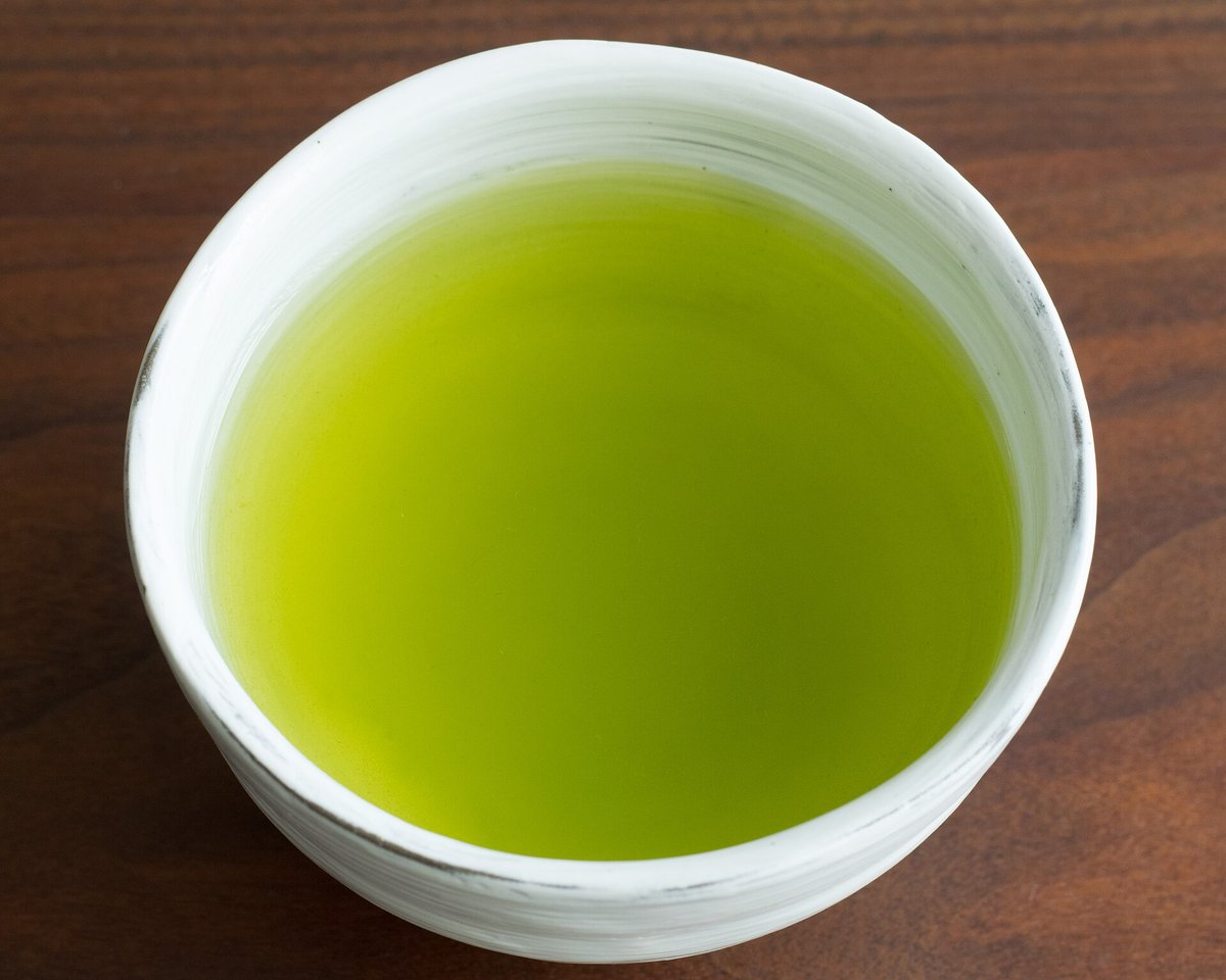 Feuilles de thé vert infusées dans une tasse claire
